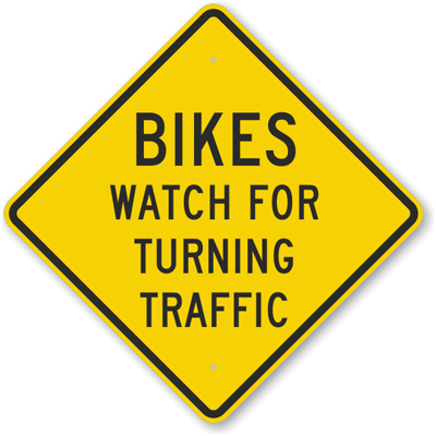 Safety sign, bikes watch for turning traffic.