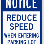 Notice reduce speed when entering a parking lot sign
