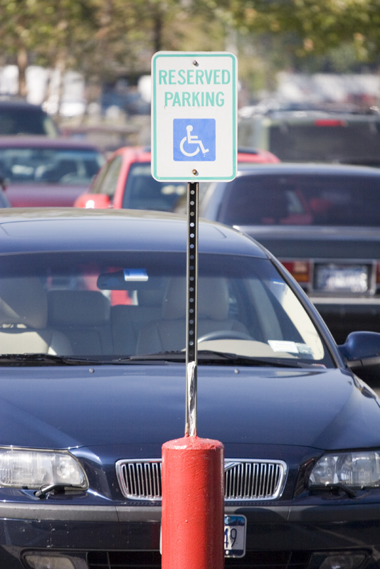 handicapped parking sign on post in lot